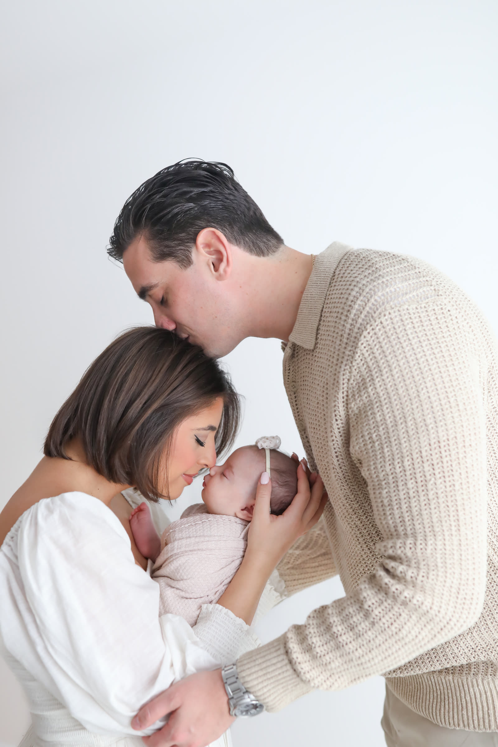 Newborn held by her parents